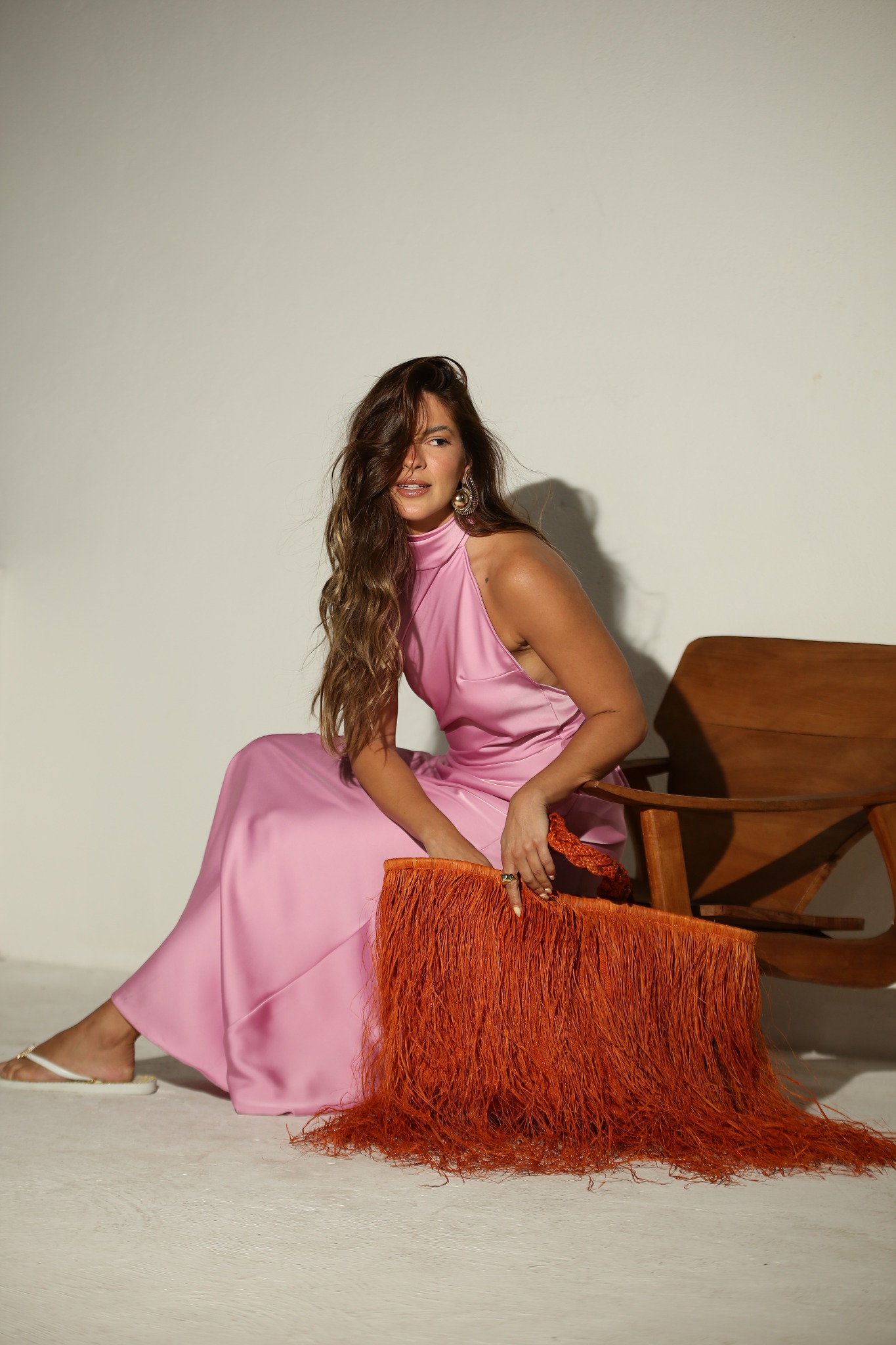 Retrato com vestido rosa e bolsa laranja com franjas